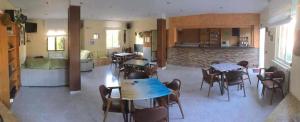 a living room with tables and chairs and a kitchen at Albergue Ciudad del Doncel in Sigüenza