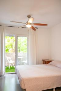een slaapkamer met een bed en een plafondventilator bij Estancia Mar y Montaña in Jávea