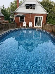 a large blue swimming pool in front of a house at Comfort Home Toronto in Toronto