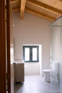 ein Badezimmer mit Waschbecken und Toilette und einem Fenster in der Unterkunft Casa da Ladeira in Videmonte + 26 Fotos