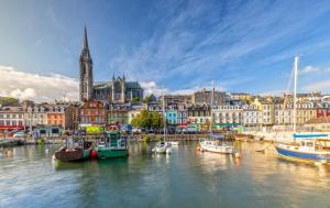 a group of boats docked in a harbor with a city at Cathedrals Corner Cobh in Cobh +2 photos