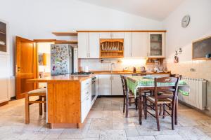 a kitchen with white cabinets and a table and chairs at Villa Pilato in Poggio Dei Pini