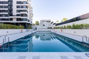 an empty swimming pool in front of a building at Be Casa - Valdebebas in Madrid