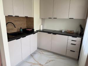 a kitchen with white cabinets and a sink at Apartament Grodzka in Wałbrzych