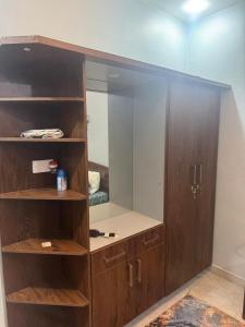 a wooden cabinet with a mirror in a room at 1 Bed Room Apartment near Tariq road in Karachi +12 photos
