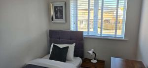 een slaapkamer met een bed, een raam en een kussen bij Spacious Luxurious Serviced Accommodation 7 in Preston