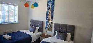 een slaapkamer met twee bedden met blauw en wit bij Spacious Luxurious Serviced Accommodation 7 in Preston