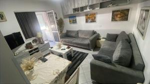 a living room with a couch and a table at Cozzy Studio Flat in Tirana