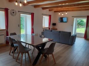 a living room with a table and chairs and a couch at Chez le Bessou 