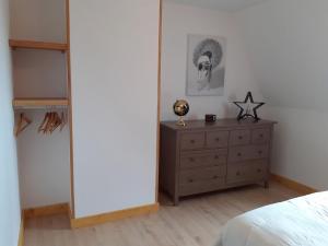 a bedroom with a bed and a dresser with a mirror at Chez le Bessou 