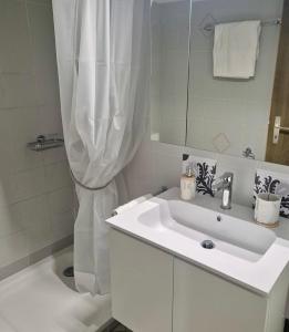 a white bathroom with a sink and a shower at Torretta House in Locarno +17 photos