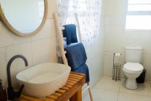 a bathroom with a sink and a toilet and a mirror at 7 Oaks in Kenton on Sea
