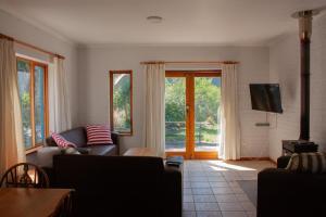 a living room with a couch and a tv at Yellowwood Place in Bettyʼs Bay