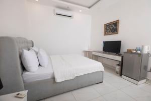 a bedroom with a bed and a television in it at White Diamond Airport Hotel in Ho Chi Minh City