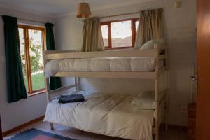 a bedroom with two bunk beds in a house at Yellowwood Place in Bettyʼs Bay