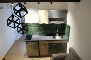 cocina con azulejos verdes en la pared y fregadero en Central House Niš, en Niš