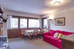 ein Wohnzimmer mit einem roten Sofa und einem Tisch in der Unterkunft Chesa San Gian first floor - Celerina in Celerina