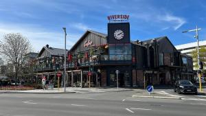 a building with a clock tower on a city street at Cosy CBD 1 Bedroom Apartment in Christchurch