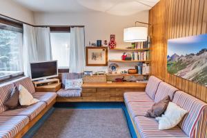 a living room with two couches and a tv at Chesa San Gian ground floor - Celerina in Celerina