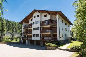 a large apartment building with a gambrel roof at Chesa San Gian ground floor - Celerina in Celerina