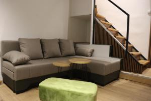 a living room with a couch and two tables at Central House Niš in Niš