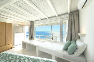 a bedroom with a bed and a large window at Eagles Nest Mykonos in Tourlos