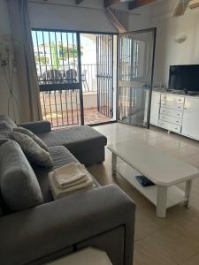 Una sala de estar con un sofá y una mesa de café. en TropicanaB11, en Nerja