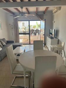 Una sala de estar con una mesa y sillas blancas. en TropicanaB11, en Nerja