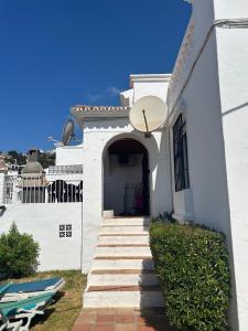 una casa blanca con escaleras que conducen a una puerta en TropicanaB11, en Nerja