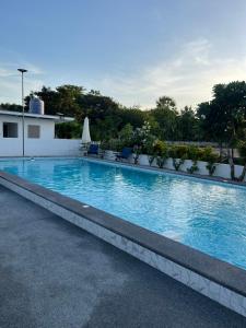 a large blue swimming pool with chairs and a building at AJ Pizza and Steakhouse in Ban Khai Nun
