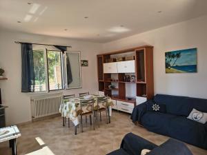 a living room with a table and a blue couch at Casa indipendente Roque Vista al mar con parking gratuito in Vallecrosia