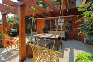 Un patio con mesa y sillas y un columpio. en Luxury Tbilisi House with Garden - by Wehost, en Tiflis