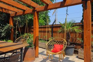 un patio con 2 sillas y una pérgola de madera en Luxury Tbilisi House with Garden - by Wehost, en Tiflis