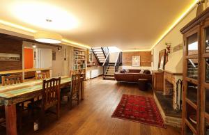 Una sala de estar con una mesa y sillas y un sofá. en Luxury Tbilisi House with Garden - by Wehost, en Tiflis