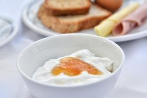a bowl of whipped cream and toast on a table at Hotel Korali in Troulos