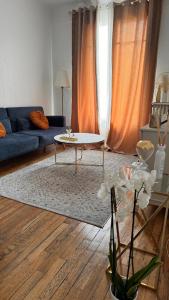 a living room with a couch and a table at Nid Douillet au Calme Parfait pour se Ressourcer in Noisy-le-Sec