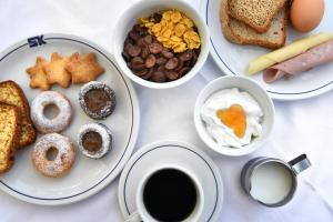 a table with plates of breakfast foods and a cup of coffee at Hotel Korali in Troulos