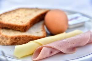 a plate of food with ham and eggs and toast at Hotel Korali in Troulos