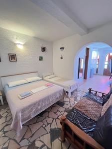 a room with two beds and a chair in it at Vila Tesmija in Baška