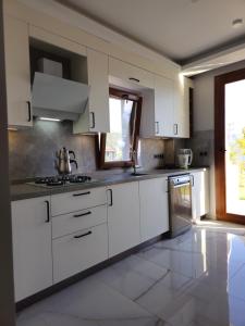 a large kitchen with white cabinets and a sink at Asiyan Villas in Marmaris