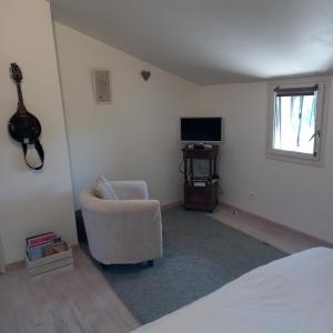 a bedroom with a bed and a chair and a television at Malpas125 chambres in Accons