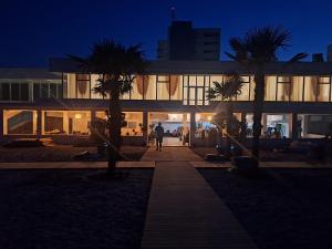a building with palm trees in front of it at night at Hotel Meteor in Jupiter