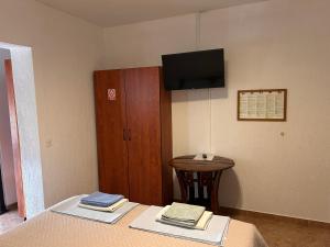 a room with a bed and a table and a television at Vila Tesmija in Baška
