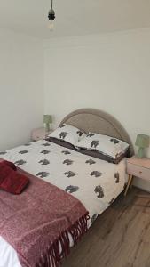 a bedroom with a bed with two night stands and two tables at Sea view two bedroom apartment in Hastings