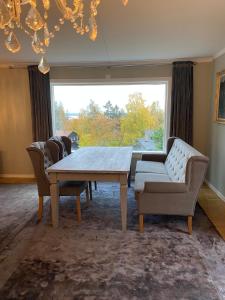a dining room with a table and chairs and a large window at Family-Friendly Villa in Oslo - Holmenkollen in Oslo