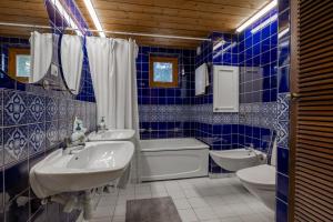 a blue tiled bathroom with a tub sink and toilet at Scenic Lakehouse near Stockholm with Sauna & Jetty in Huddinge +38 photos