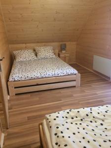 ein Schlafzimmer mit zwei Betten in einem Holzzimmer in der Unterkunft Domek z widokiem na góry in Targoszów