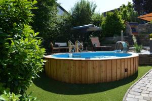 a circular pool in a garden with a wooden fence at Komfort-Apartment Mit Terrasse in Estenfeld