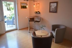 a living room with a table and chairs at Komfort-Apartment Mit Terrasse in Estenfeld +2 photos