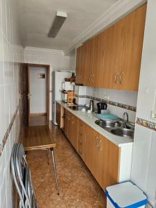 Una cocina con gabinetes de madera y un fregadero. en Casa Moli Ronda Parking gratis, en Ronda